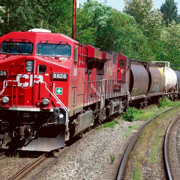 Red Canadian train locomotive on tracks, perfect for displaying in an LED Box Frame for train collectors.