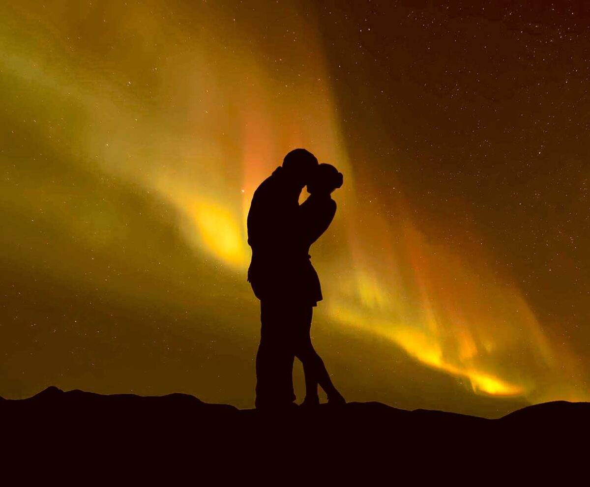 Couple silhouette against the Northern Lights in a romantic moment, perfect for LED Box Frames.