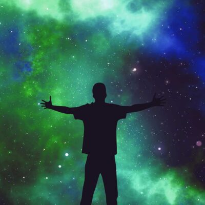 Person with arms outstretched standing against a vibrant cosmic space backdrop captured in an LED Box Frame