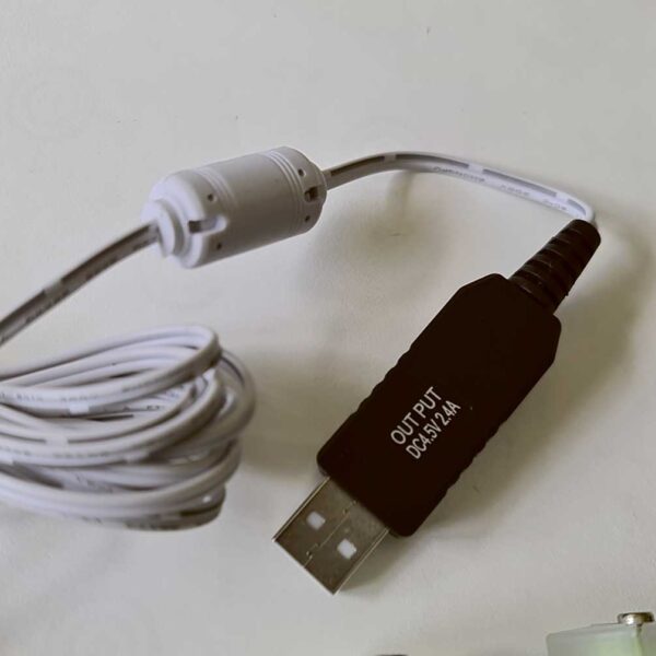 Close-up of a 3-meter USB battery eliminator wire with labeled output and coiled cable on a white surface.