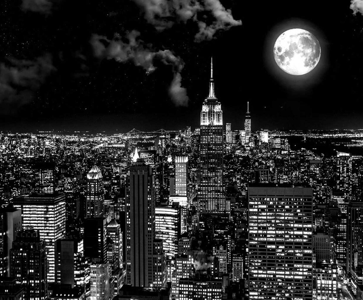 New York City skyline at night with a full moon glowing above the Empire State Building