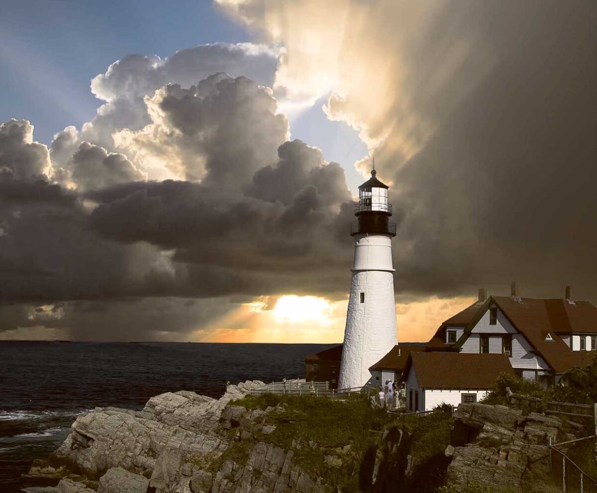 A lighthouse stands strong on rocky cliffs as storm clouds part and sunlight streams through over the ocean