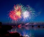 A breathtaking fireworks display captured at night, with vibrant colors and reflections over the water, presented in a customizable LED Box Frame for an eco-friendly, energy-efficient lighting experience.