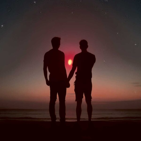 Couple holding hands during a romantic sunset on the beach, captured in a customizable LED Box Frame with energy-efficient lighting